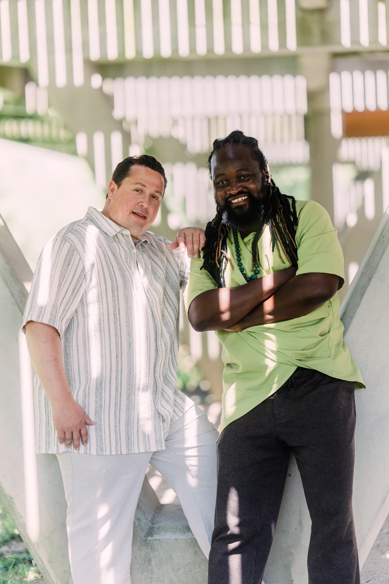 Serge Kakudji et David Demange posant ensemble sous une structure claire