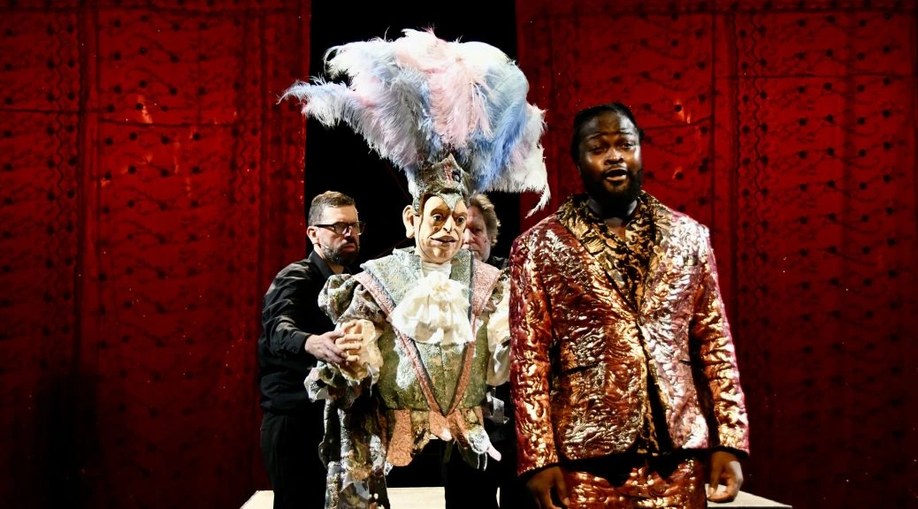 Serge Kakudji aux côtés d’une marionnette costumée sur la scène de DIVA