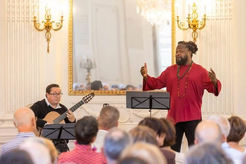 Serge Kakudji chantant aux côtés du guitariste David Demange à Ronchamp